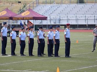 student cadets standing at attention on field